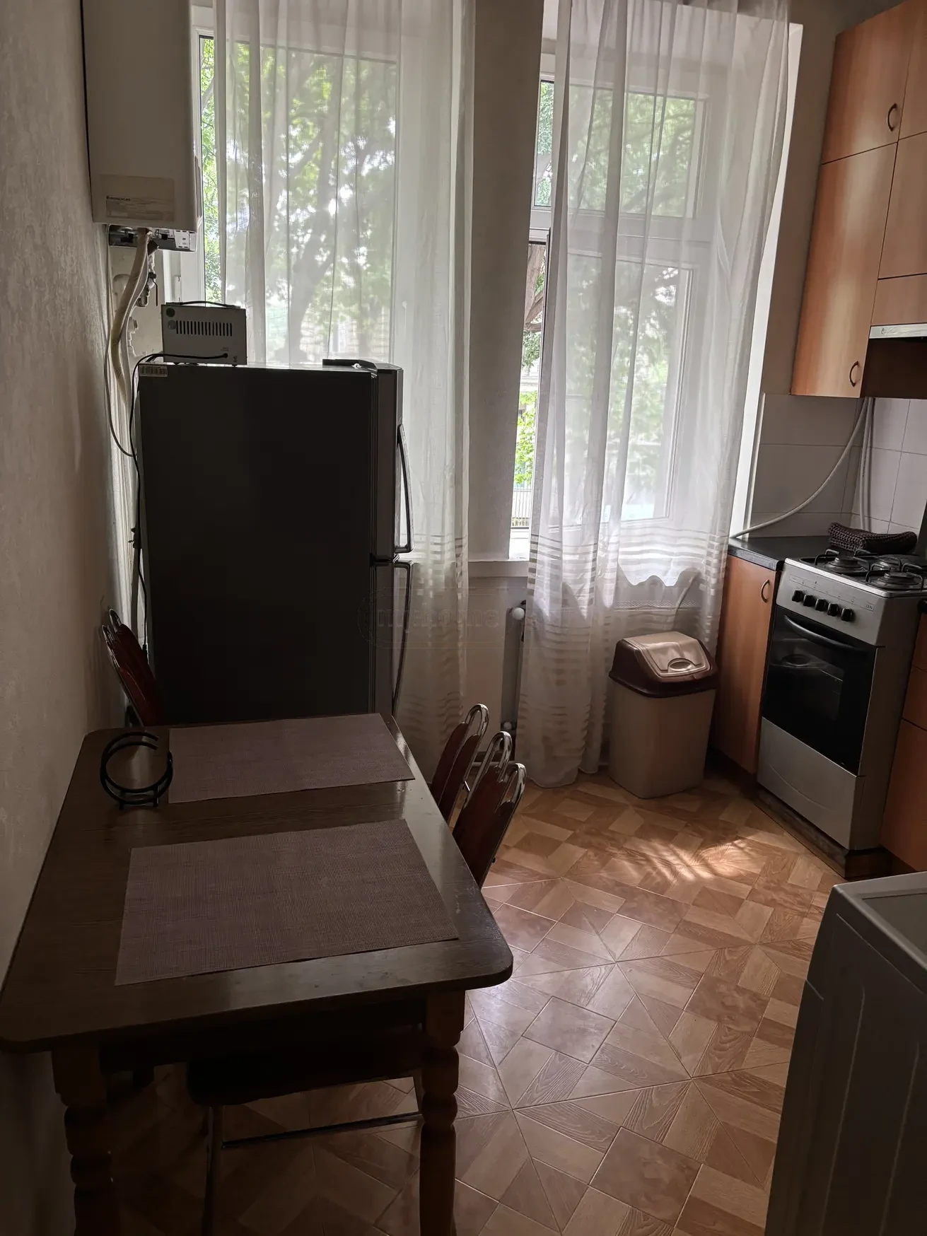 1-room apartment for rent on Aghmashenebeli Avenue, Chugureti, Tbilisi — kitchen with dining table, fridge and gas stove