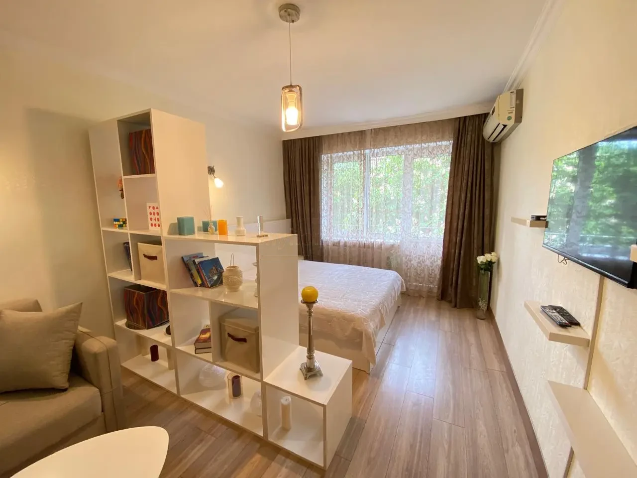 1-room apartment for rent on Vazha-Pshavela Avenue, Saburtalo, Tbilisi — main room with AC and TV toward the window