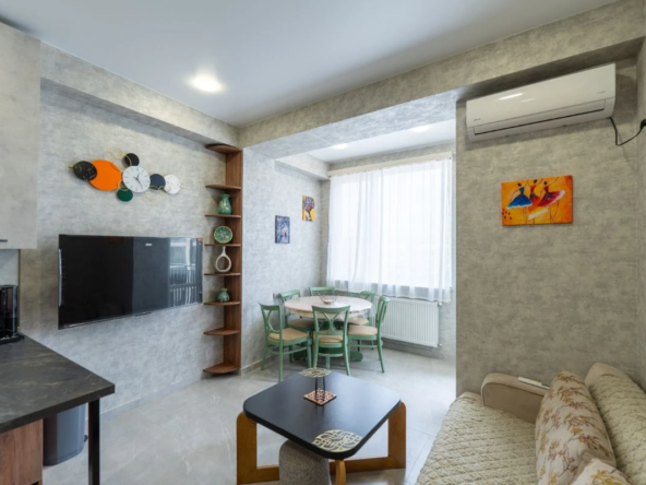 2-room apartment for rent on Chavchavadze Avenue 49b, Vake, Tbilisi — living room with dining table, TV and wall art