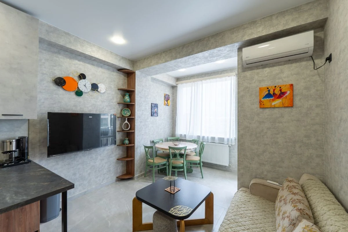 2-room apartment for rent on Chavchavadze Avenue 49b, Vake, Tbilisi — living room with dining table, TV and wall art