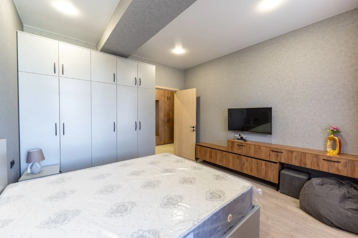 2-room apartment for rent on Chavchavadze Avenue 49b, Vake, Tbilisi — bedroom with fitted wardrobes and TV