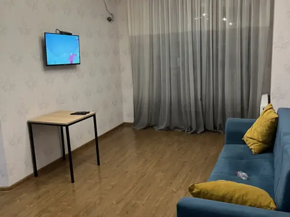 2-room apartment for rent on Chkondideli Street, Nadzaladevi, Tbilisi — living room with sofa and TV