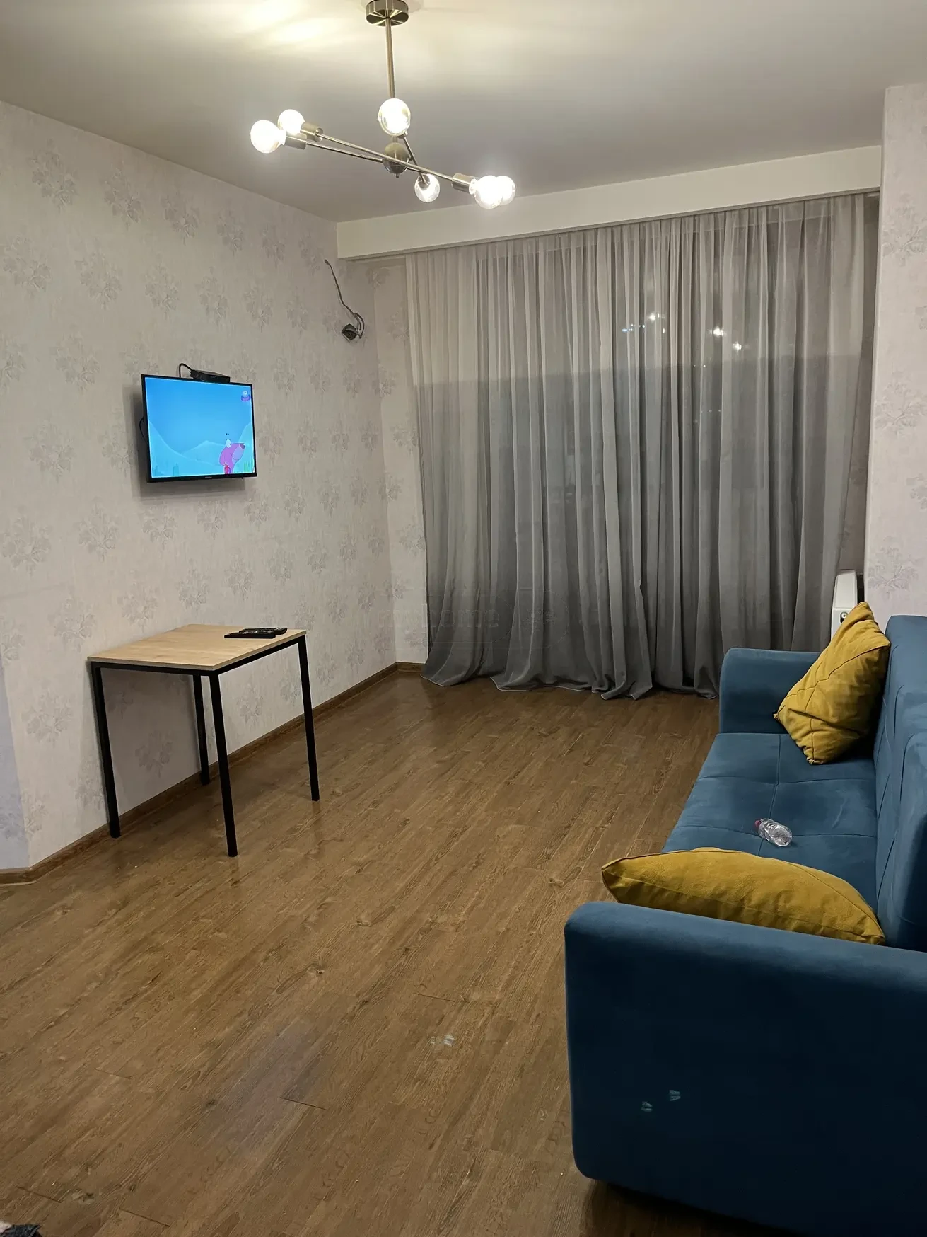 2-room apartment for rent on Chkondideli Street, Nadzaladevi, Tbilisi — living room with sofa and TV