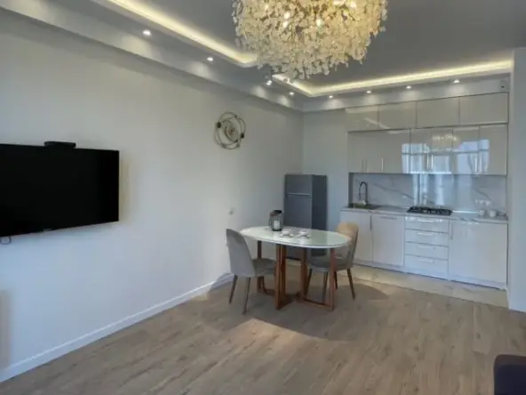 2-room apartment for rent on Chkondideli Street 36, Nadzaladevi, Tbilisi — living room with chandelier and open kitchen