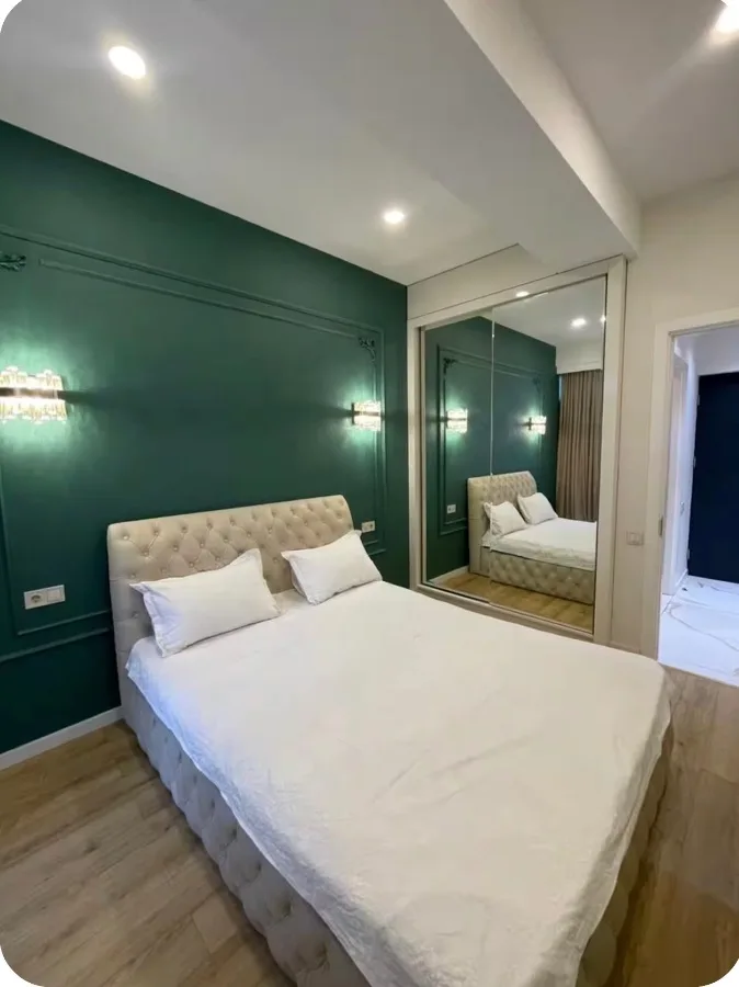 2-room apartment for rent on Chkondideli Street 36, Nadzaladevi, Tbilisi — bedroom with green accent wall and mirrored wardrobe