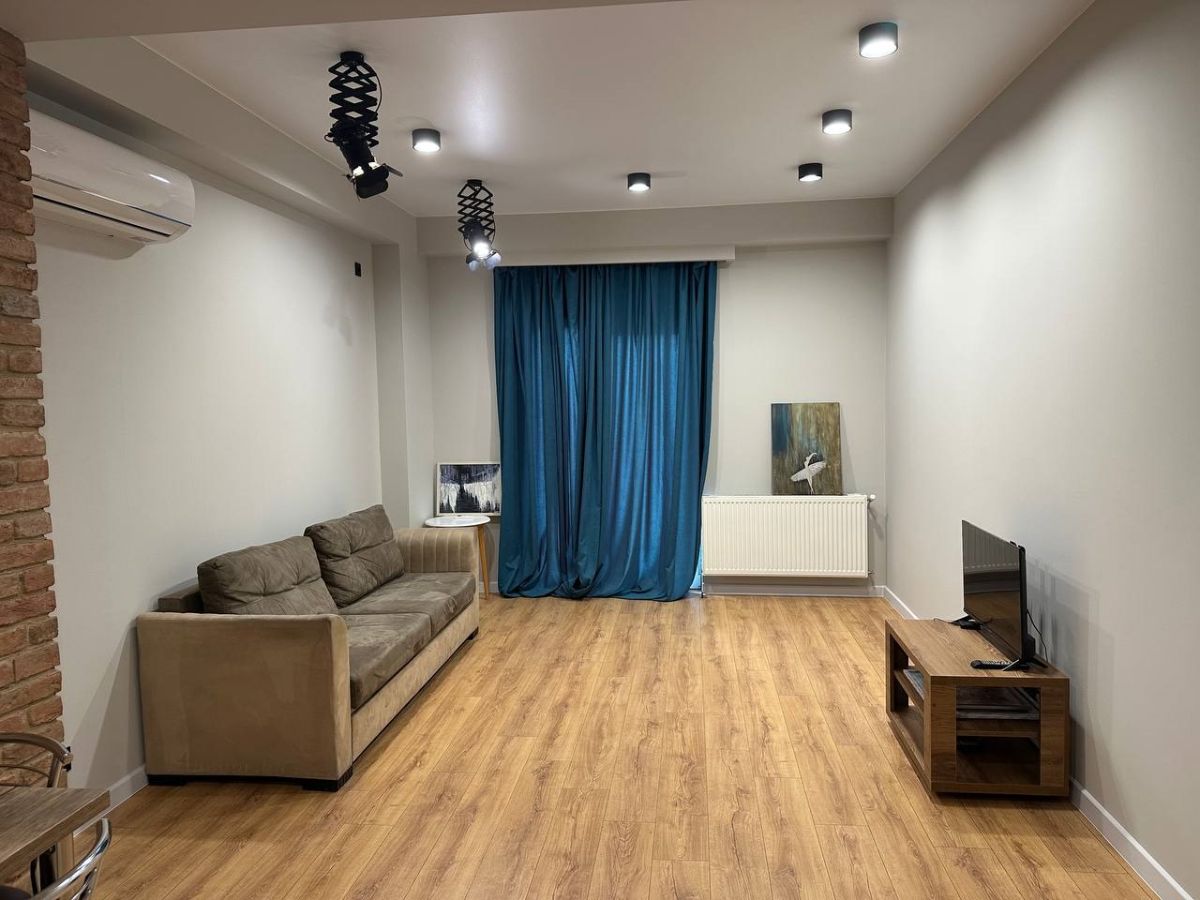 2-room apartment for rent on Chkondideli Street, Nadzaladevi, Tbilisi — living room with sofa and teal curtains