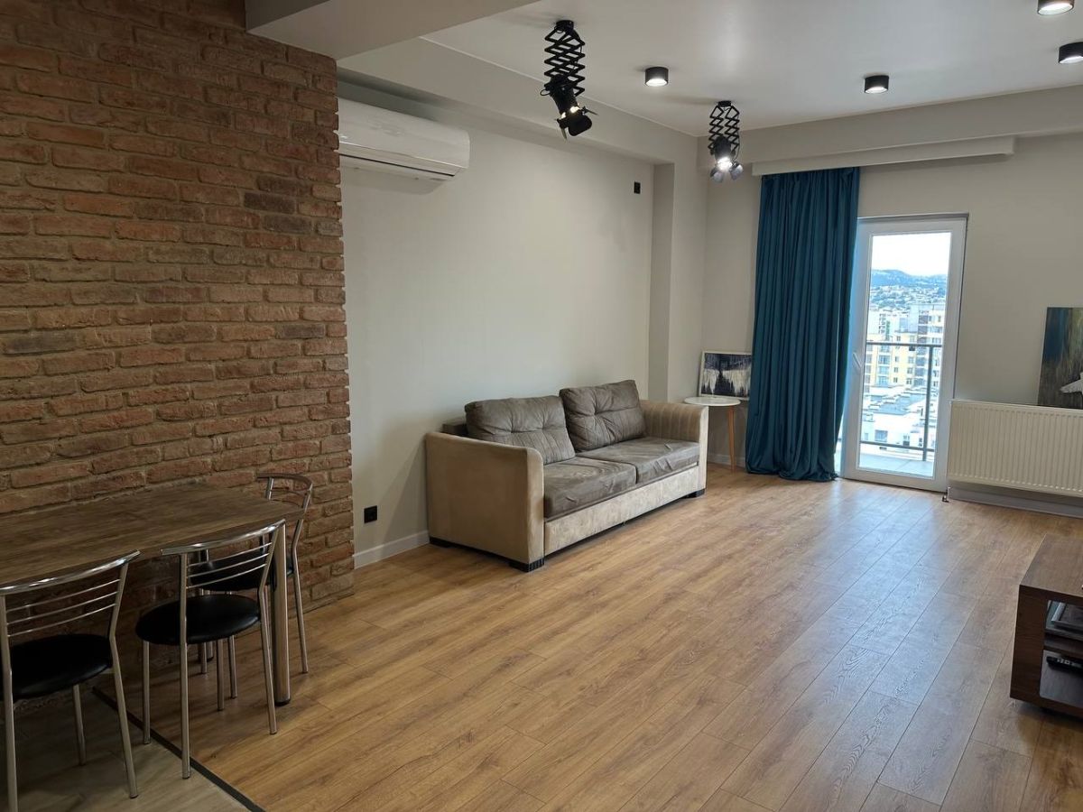 2-room apartment for rent on Chkondideli Street, Nadzaladevi, Tbilisi — living room with exposed brick wall and dining area