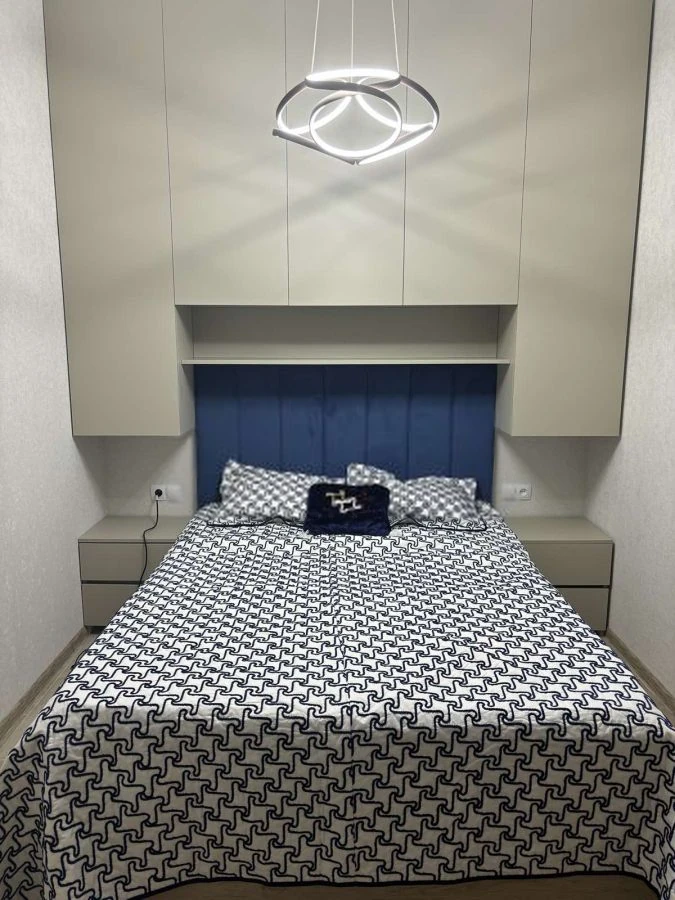 2-room apartment for rent on Chqondideli Street, Nadzaladevi, Tbilisi — bedroom with upholstered blue headboard and built-in wardrobes