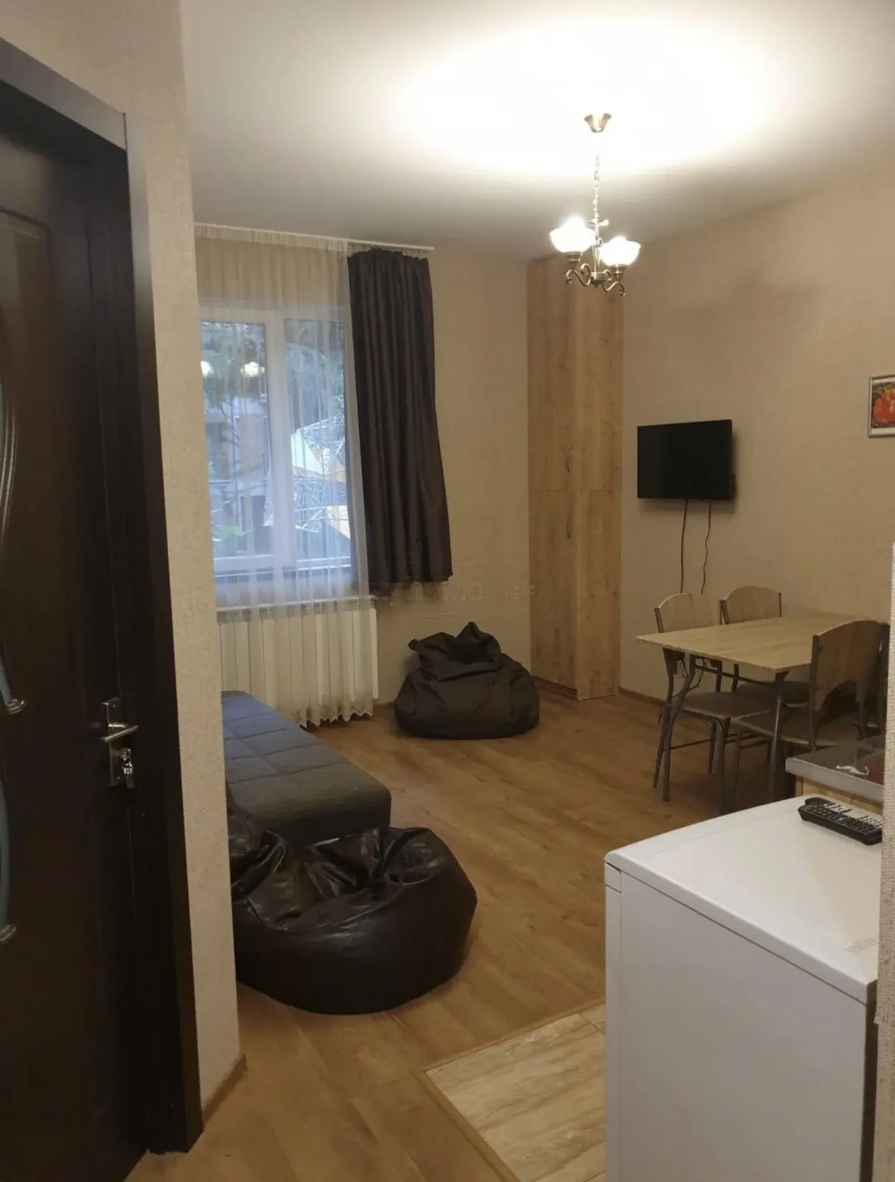 2-room apartment for rent on Politkovskaya Street (Jikia), Saburtalo, Tbilisi — living room with dining table and TV