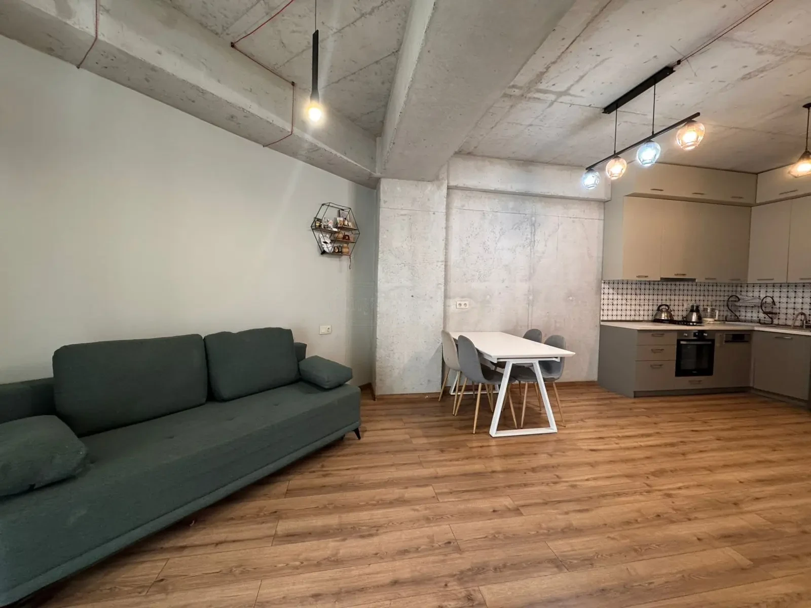 2-room apartment for sale on Avalishvili Street, Vake, Tbilisi — living room with sofa and open built-in kitchen