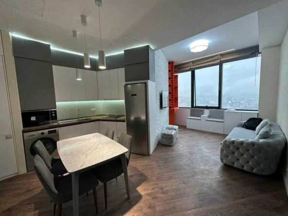 2-room apartment for sale on Ilia Chavchavadze Avenue, Vake, Tbilisi — open-plan living room, kitchen and dining area with floor-to-ceiling city windows