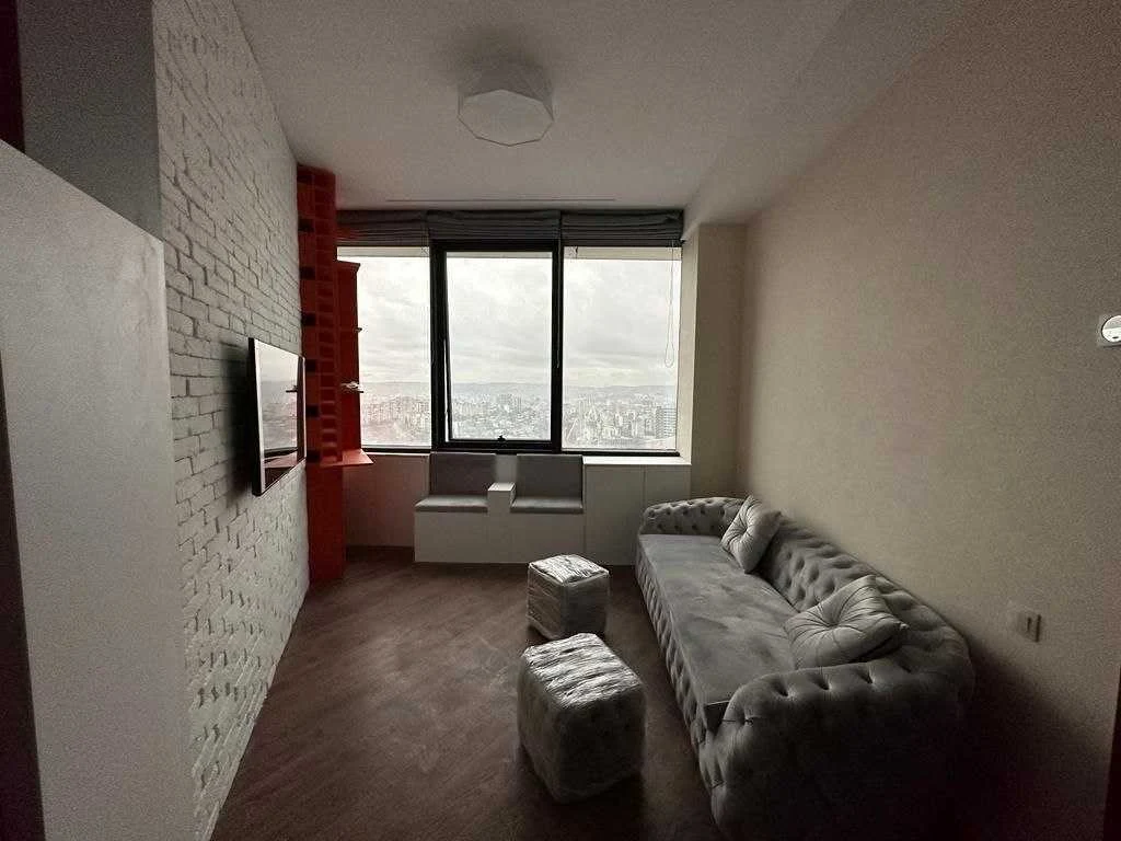 2-room apartment for sale on Ilia Chavchavadze Avenue, Vake, Tbilisi — seating area with a grey velvet sofa and panoramic 24th-floor city view