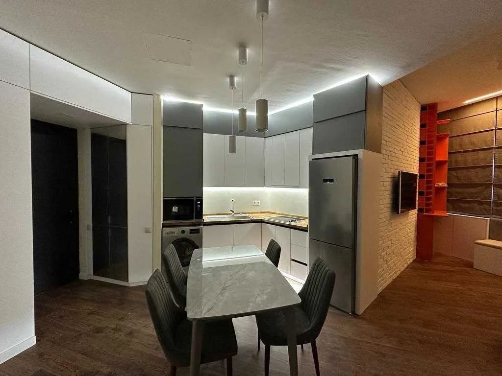 2-room apartment for sale on Ilia Chavchavadze Avenue, Vake, Tbilisi — kitchen and dining area with pendant lighting and oak-look flooring