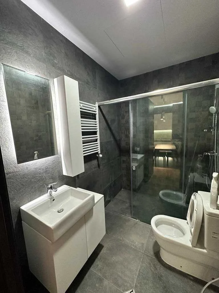 2-room apartment for sale on Ilia Chavchavadze Avenue, Vake, Tbilisi — bathroom in dark stone tile with a walk-in glass shower