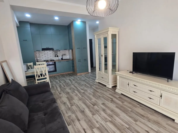 2-room furnished apartment for sale on Mindeli Street 9b, Saburtalo, Tbilisi — living room with sofa and teal kitchen