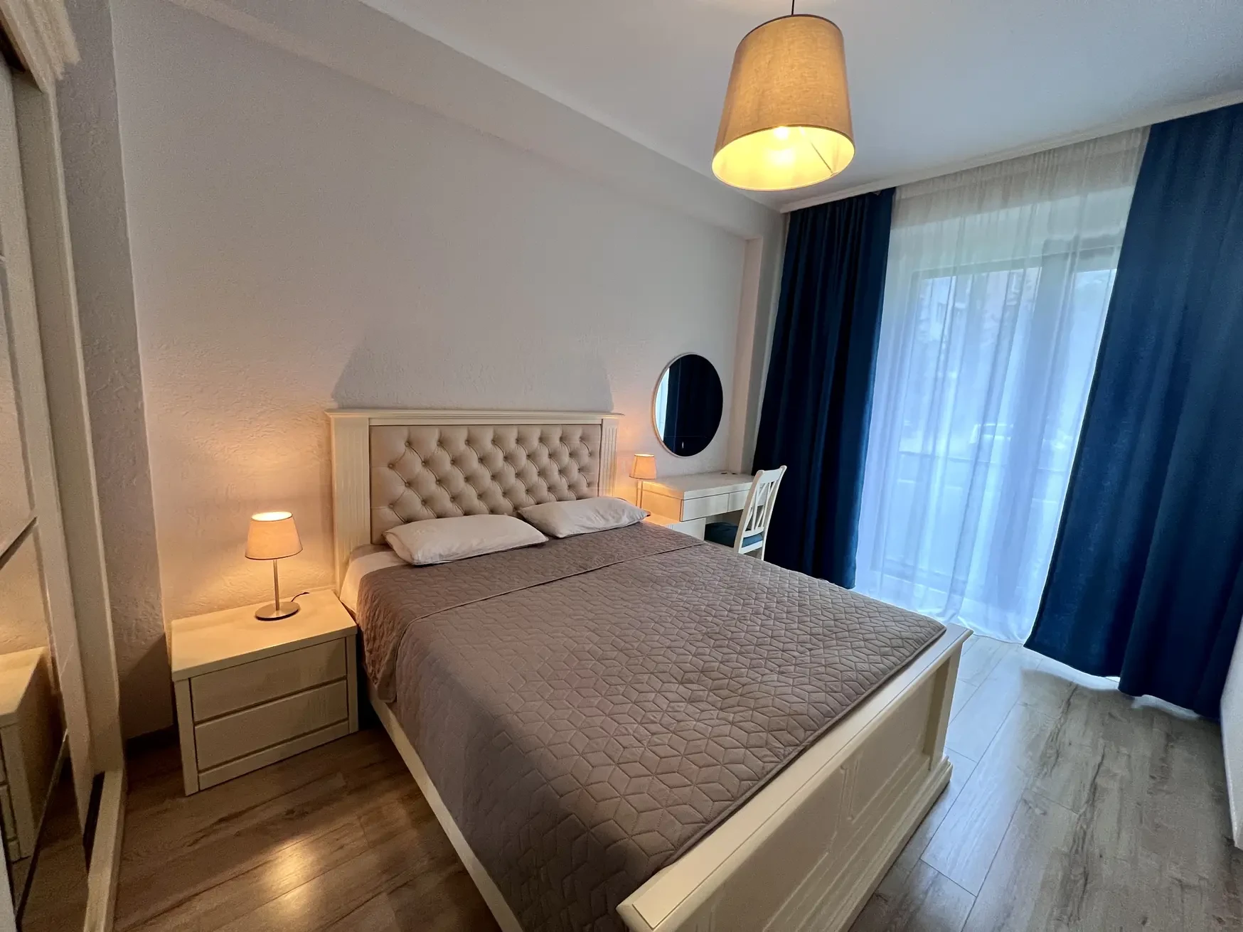 2-room furnished apartment for sale on Mindeli Street 9b, Saburtalo, Tbilisi — bedroom with upholstered bed and blue curtains