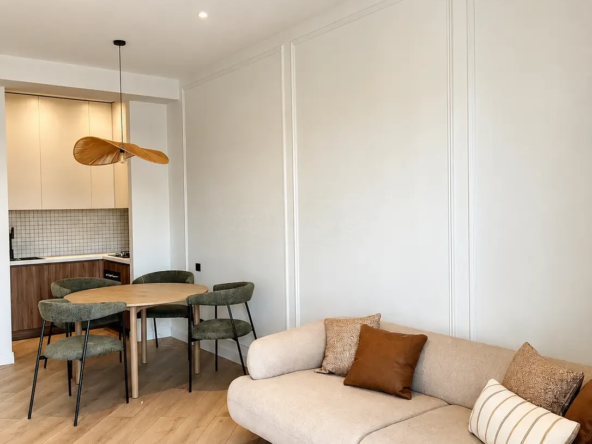 2-room furnished apartment for sale on Nutsubidze Street 125, top floor, Saburtalo, Tbilisi — living room with sofa, dining nook and open kitchen