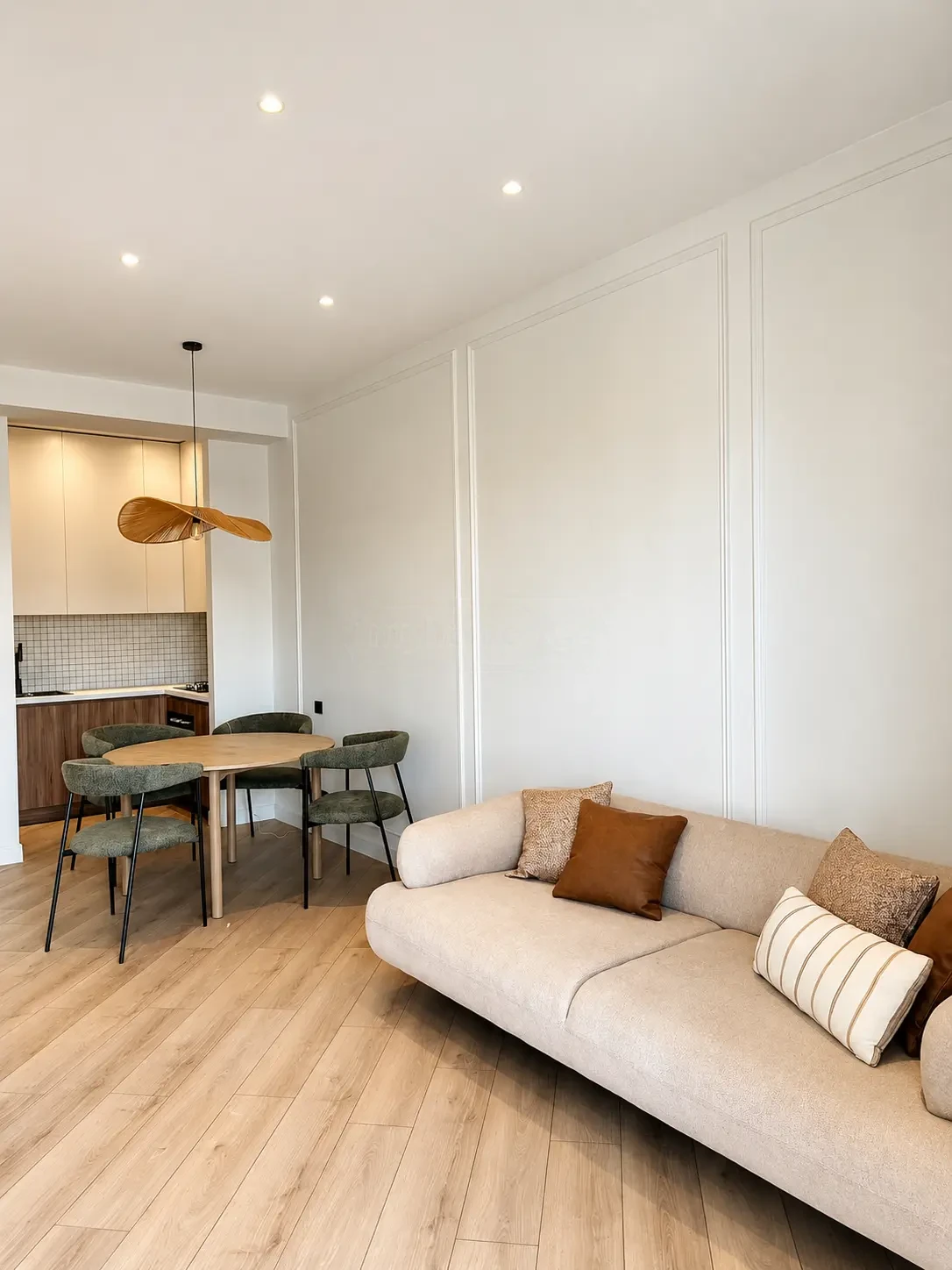 2-room furnished apartment for sale on Nutsubidze Street 125, top floor, Saburtalo, Tbilisi — living room with sofa, dining nook and open kitchen