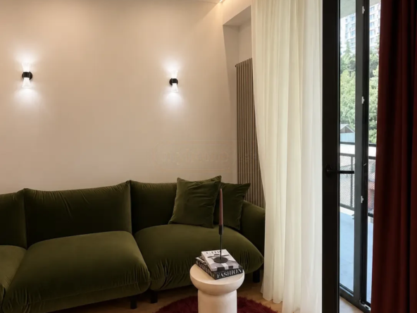 2-room apartment for sale on Nutsubidze Street 195, Saburtalo, Tbilisi — living room with green velvet sofa and balcony door