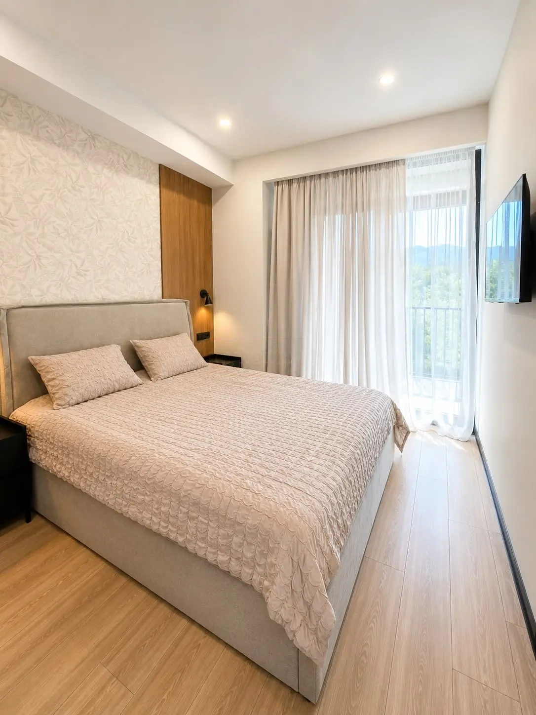 2-room furnished apartment for sale on Politkovskaya Street 46, 16th floor, Saburtalo, Tbilisi — bedroom with upholstered bed and balcony access