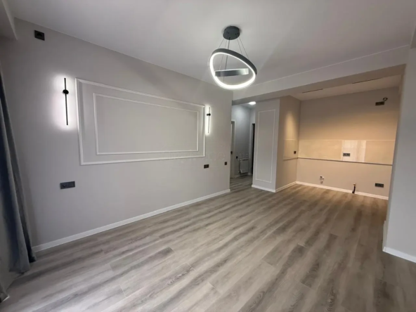 2-room apartment for sale on Politkovskaya Street, Saburtalo, Tbilisi — bright living room with ring chandelier and kitchen niche