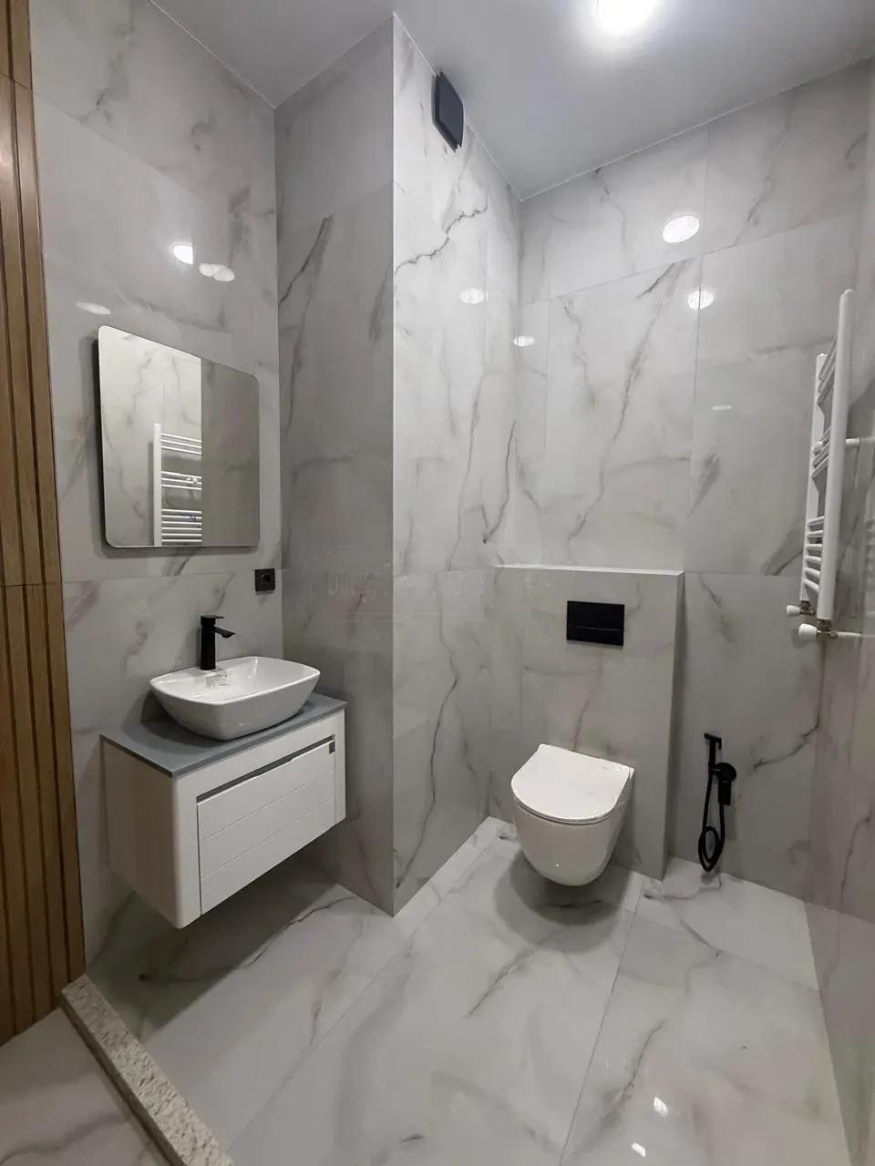 2-room apartment for sale on Politkovskaya Street, Saburtalo, Tbilisi — bathroom with marble tile, vanity and toilet