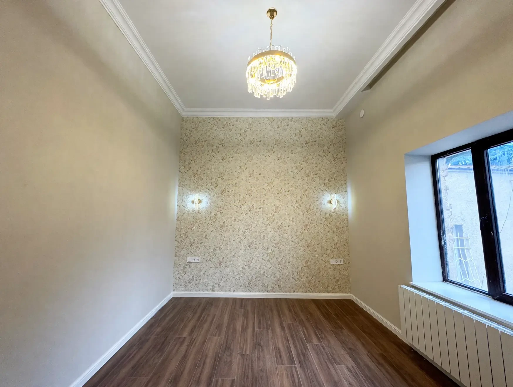 2-room apartment for sale on Tsinamdzghvrishvili Street, Chugureti, Tbilisi — bedroom with floral accent wall and wall sconces