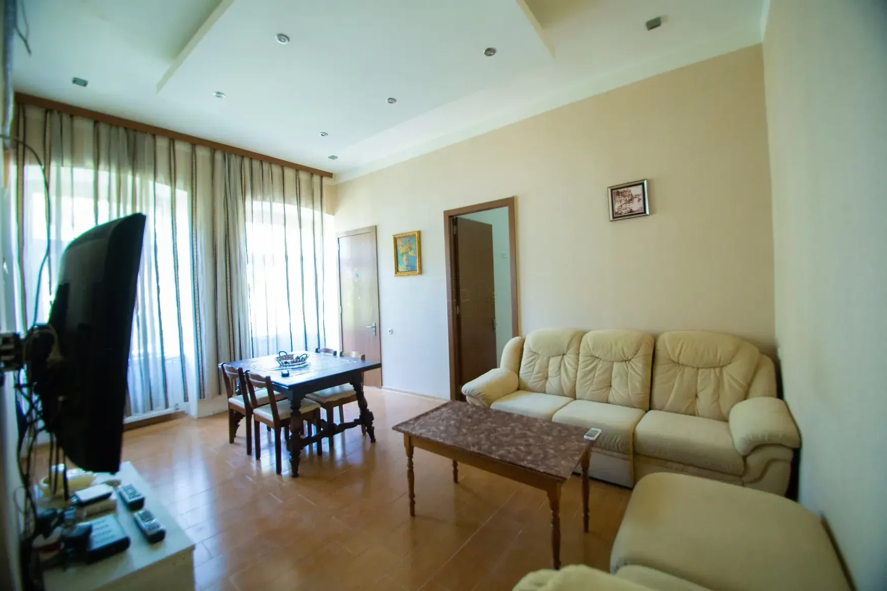 3-room apartment for rent on Tovstonogovi Street, Chugureti, Tbilisi — living room with sofa and dining table