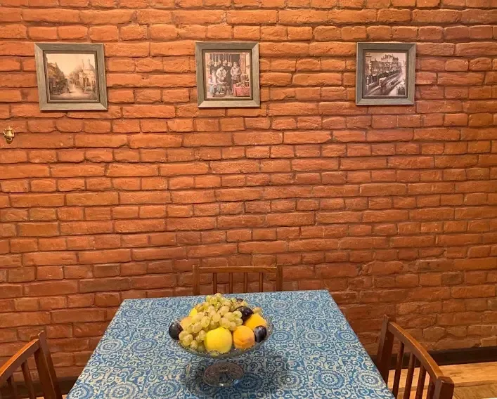3-room apartment for rent on Tsinamdzghvrishvili Street, Chugureti, Tbilisi — dining table with brick wall