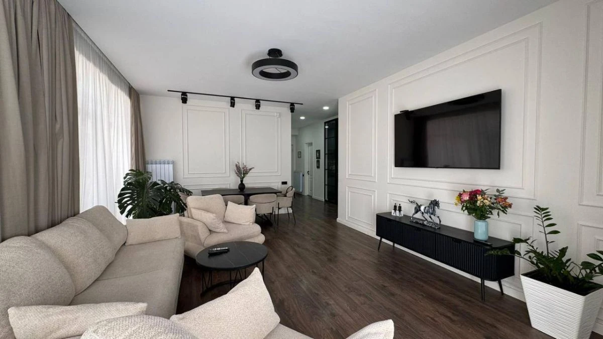 3-room apartment for sale on Nino Zhvania Street, Vake, Tbilisi — living room with wall-mounted TV and panelled walls