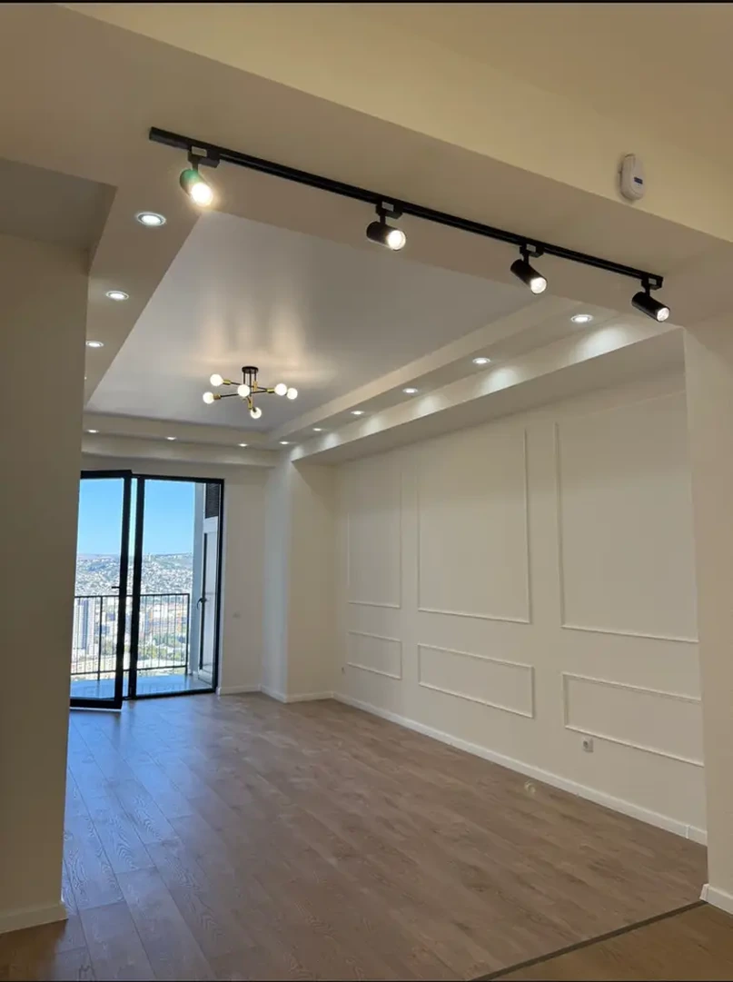 3-room apartment for sale on Shartava Street 43, Saburtalo, Tbilisi - open-plan living area with track lighting and balcony doors