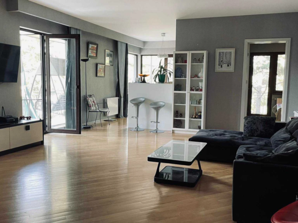 4-room apartment for rent on Titsian Tabidze Street 61, Vake, Tbilisi — living room with sofa, TV and doors to the terrace