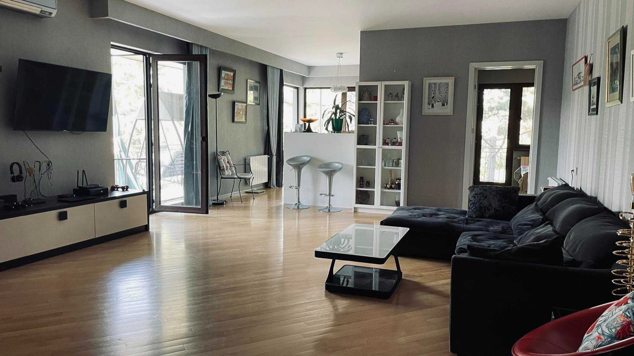 4-room apartment for rent on Titsian Tabidze Street 61, Vake, Tbilisi — living room with sofa, TV and doors to the terrace