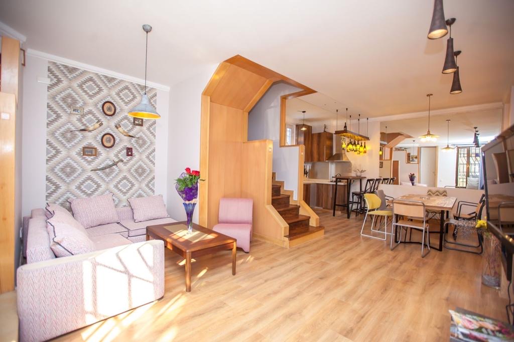 7-room house for sale on Marjanishvili Street, Chughureti, Tbilisi — open-plan living and dining room with staircase