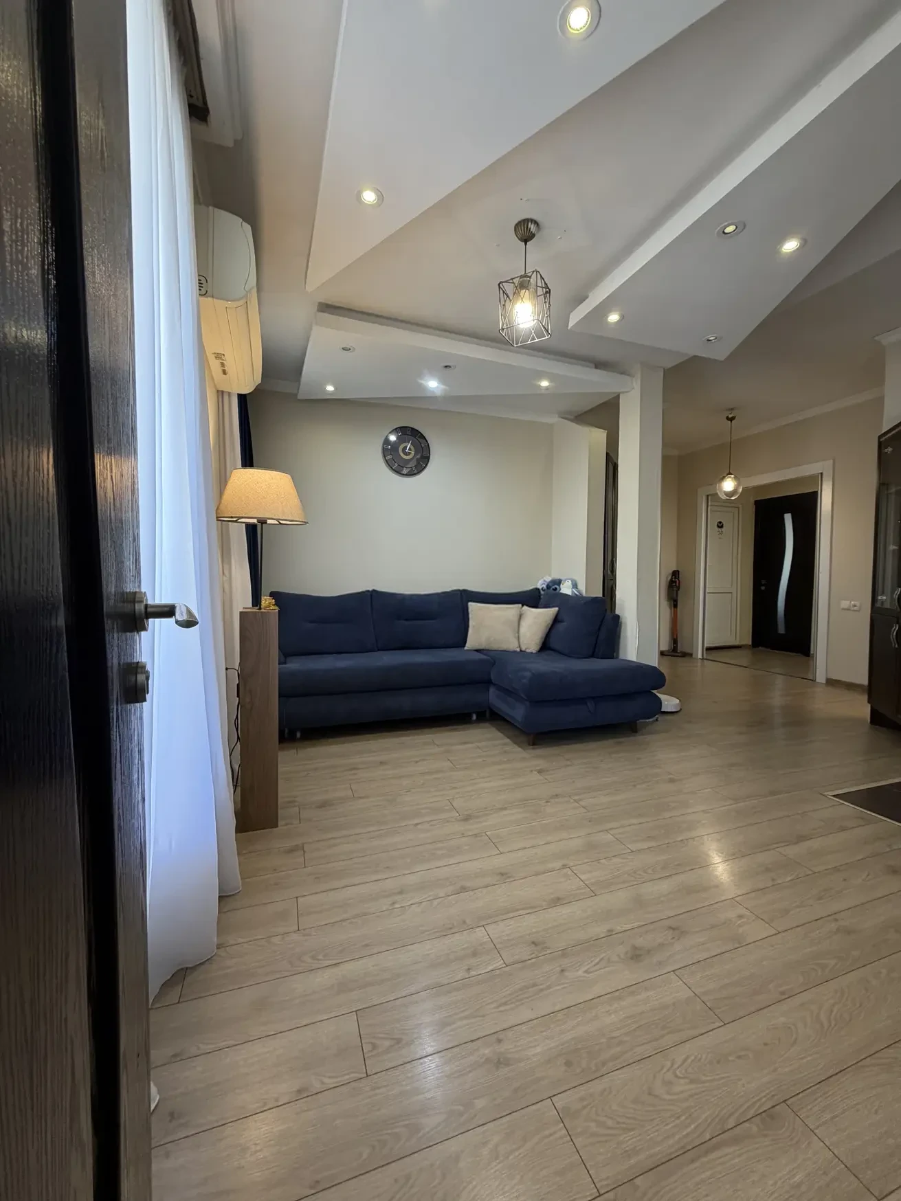 8-room house for sale on Gogi Dolidze Street, Chughureti, Tbilisi — living room with corner sofa and designer ceiling