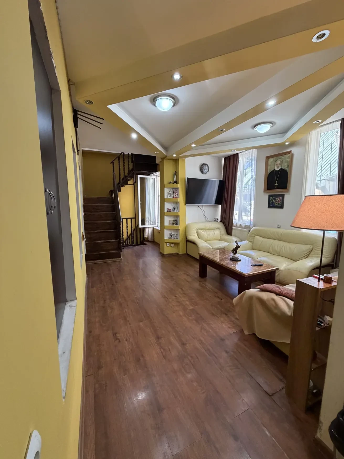8-room house for sale on Gogi Dolidze Street, Chughureti, Tbilisi — salon with wooden staircase to the upper floor