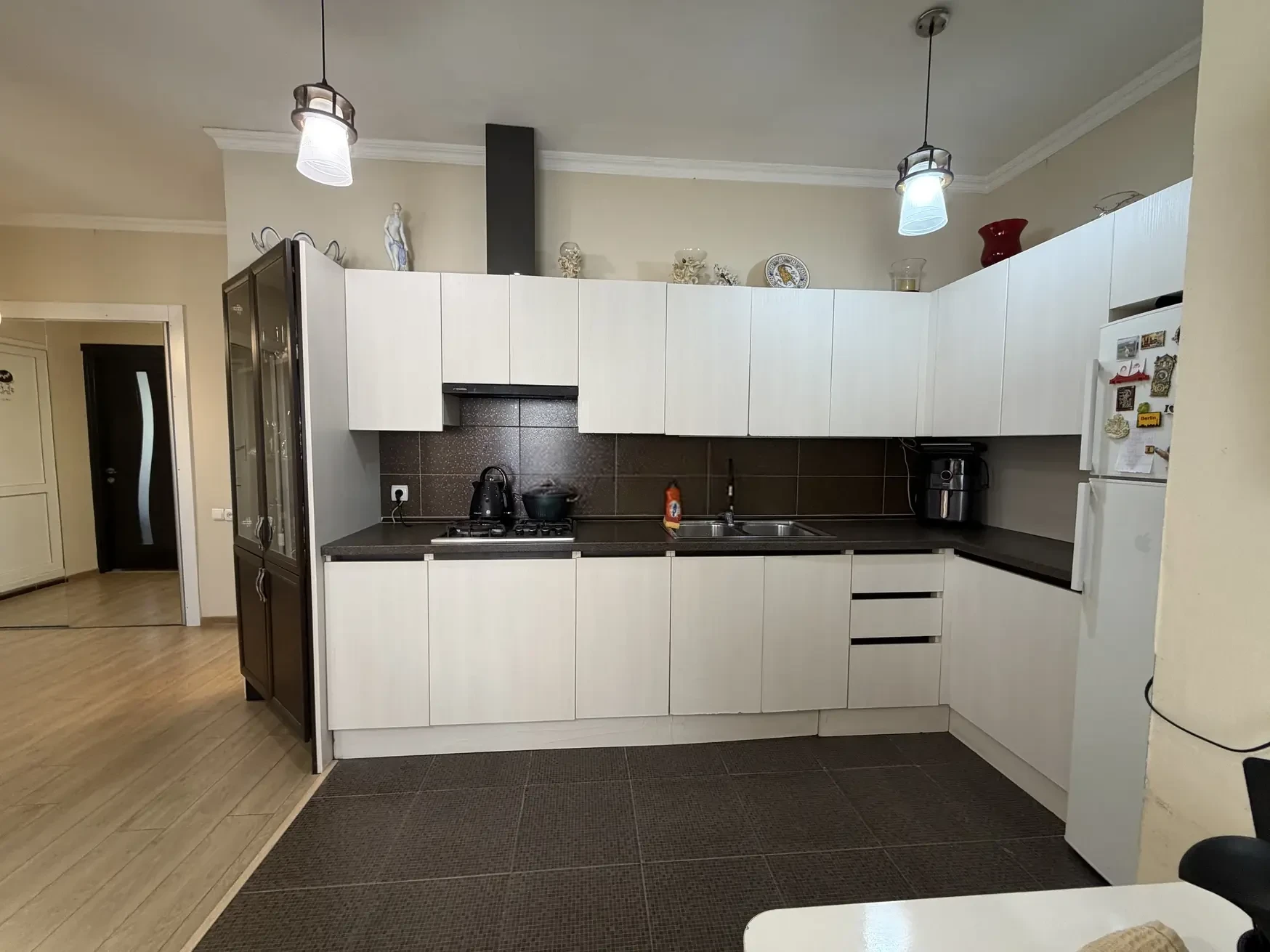 8-room house for sale on Gogi Dolidze Street, Chughureti, Tbilisi — kitchen with white cabinets and appliances