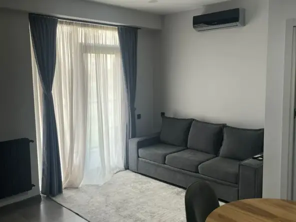 2-room apartment for sale on Marshal Gelovani Avenue, Saburtalo, Tbilisi — living room with sofa, air conditioning and balcony door