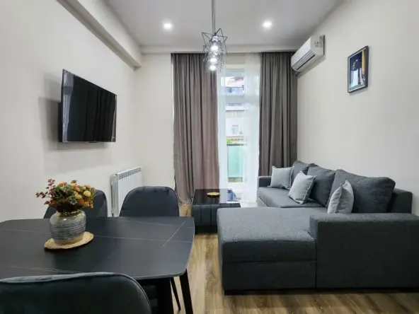 2-room apartment for sale on Pekini Avenue, Saburtalo, Tbilisi — living room with dining table and sofa