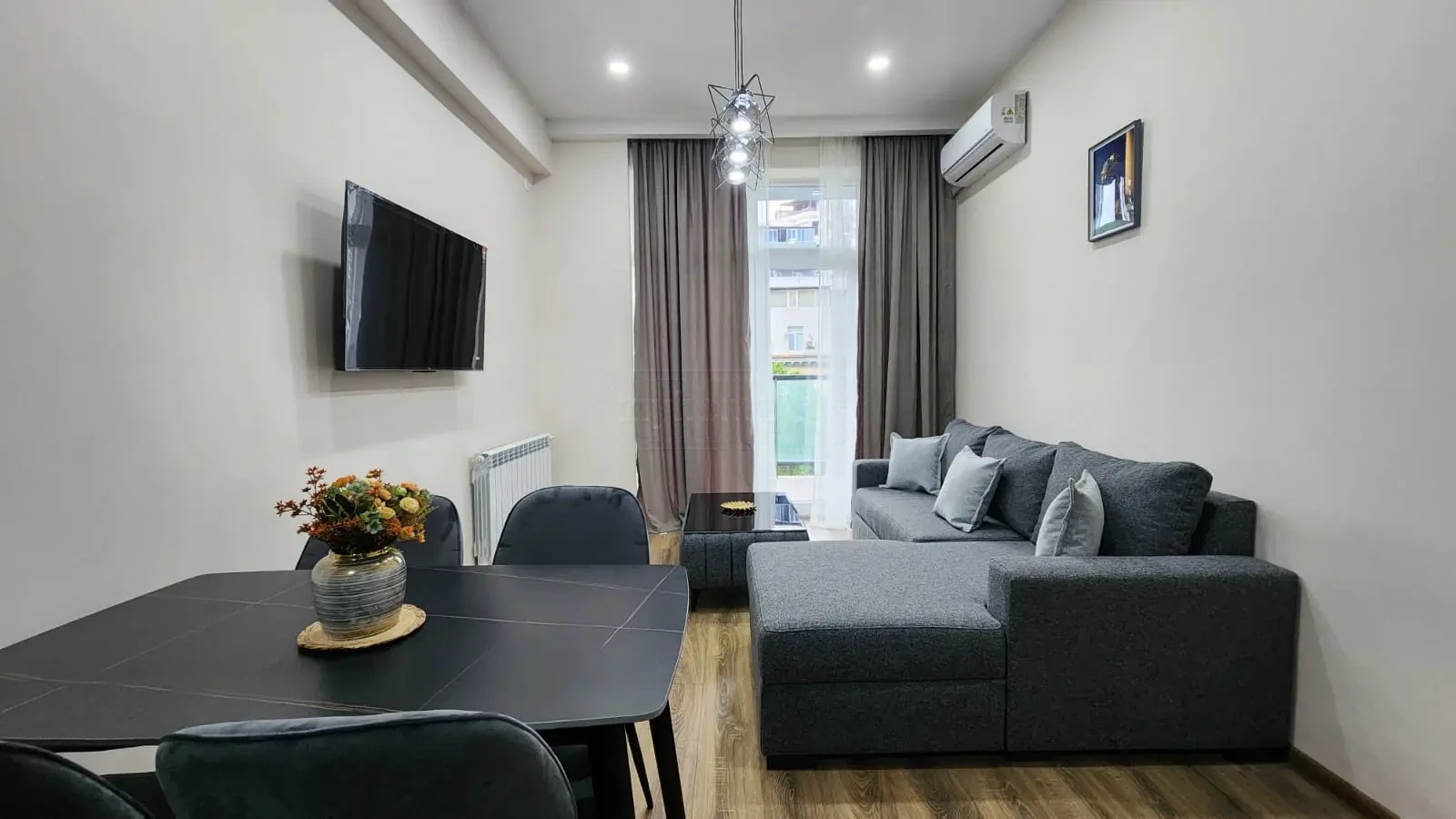 2-room apartment for sale on Pekini Avenue, Saburtalo, Tbilisi — living room with dining table and sofa