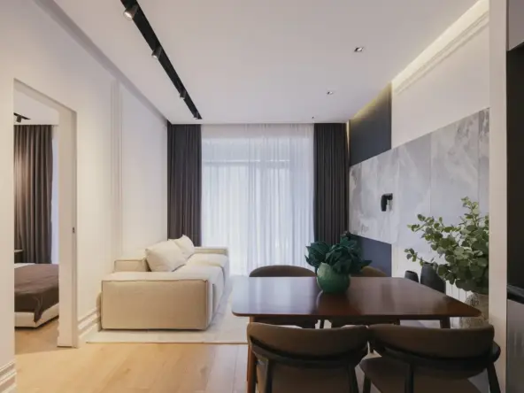 2-room apartment for sale on Politkovskaya Street 46, Saburtalo, Tbilisi — living room with sofa, dining table and balcony window